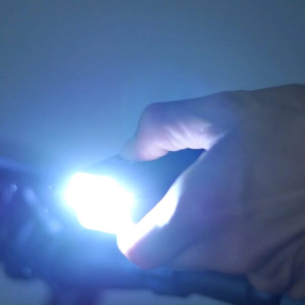 A person holding an AVENTON HEAD LIGHT V10-500 while riding an e-bike in the USA.