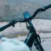 Close-up of the Soltera 2.5 Ebike handlebars, featuring a digital display screen showing ride information; the bike frame is labeled "Soltera.