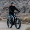 A man riding the AVENTURE.2 Step Through Ebike in the desert, using e-bikes accessories.