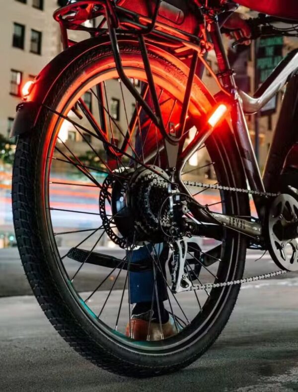 A person is riding a LEVEL.2 Commuter Ebike at night in the USA.