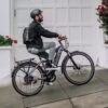 A man riding a LEVEL.2 Commuter Ebike in front of a garage in the USA.