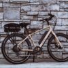 An AVENTON REAR RACK - PACE 350 / PACE 500 parked against a stone wall, featuring ebikes accessories.