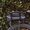 A black bicycle with an AVENTON REAR RACK - PACE 350 / PACE 500 on the back, perfect for USA riders in need of Ebikes and e-bikes accessories.