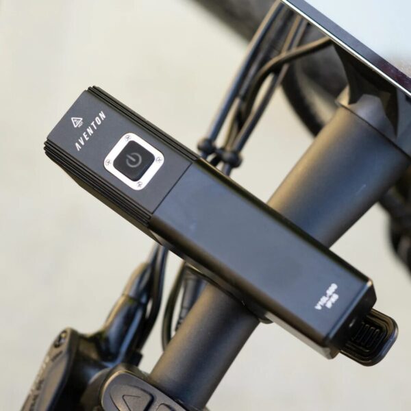 An AVENTON HEAD LIGHT V10-500 attached to the handlebar of an ebike.
