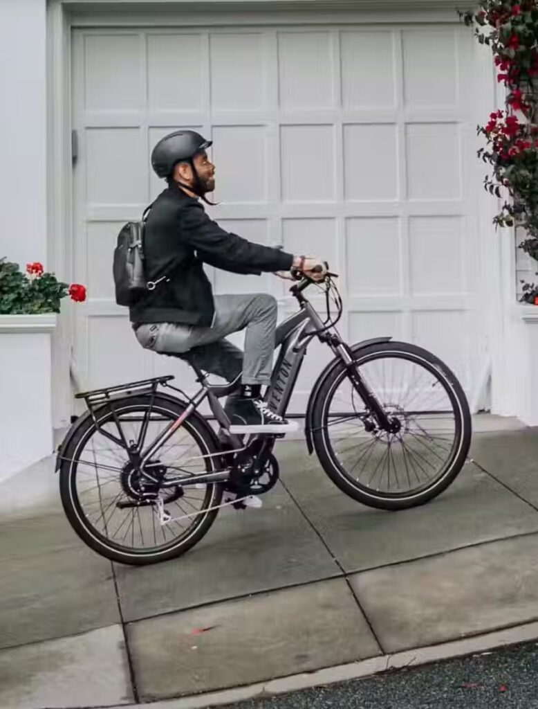 A man riding an electric bike in front of a garage in the USA.