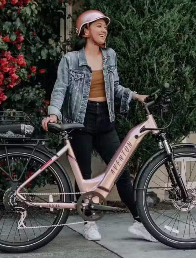 A woman is gracefully positioned next to a vibrant pink electric bike in WA, USA.