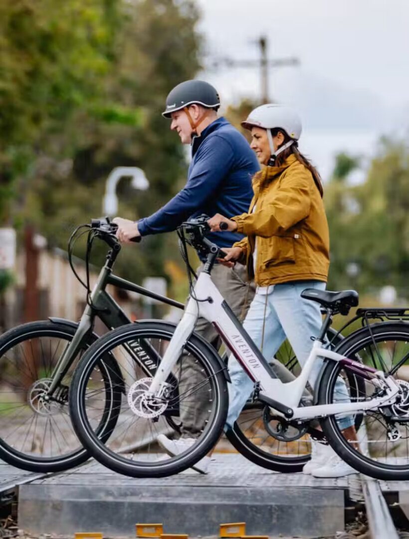 Two people riding electric bikes on a train track in the USA.