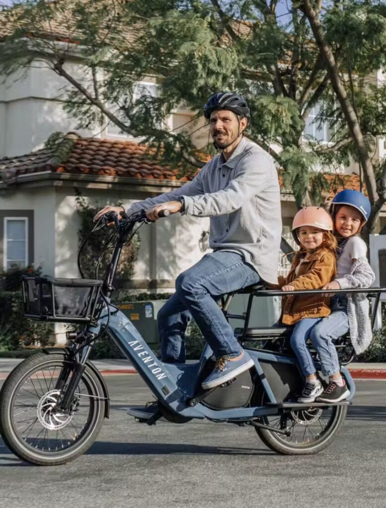 A man and two children riding on an electric scooter in the USA.