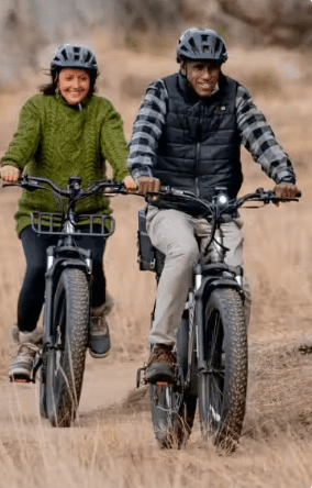 Two people riding e-bikes through a field in WA, USA.