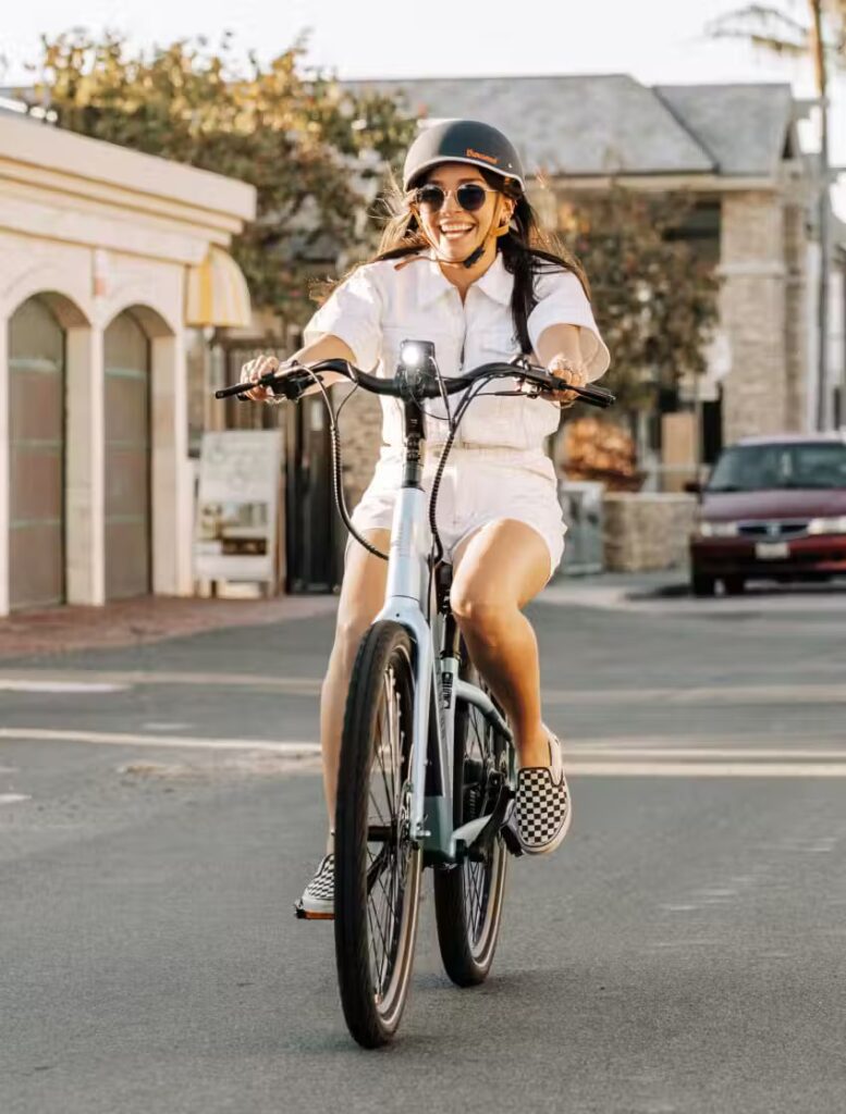A woman riding an electric bike on a street in the USA.