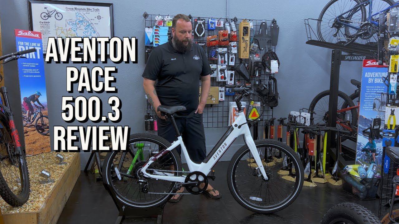 A man standing next to an aventon ebike with the words page 5003 review.