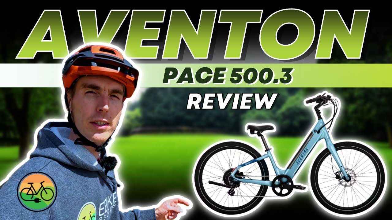 A man is standing next to a bike with the words aventon pace 5005 review.