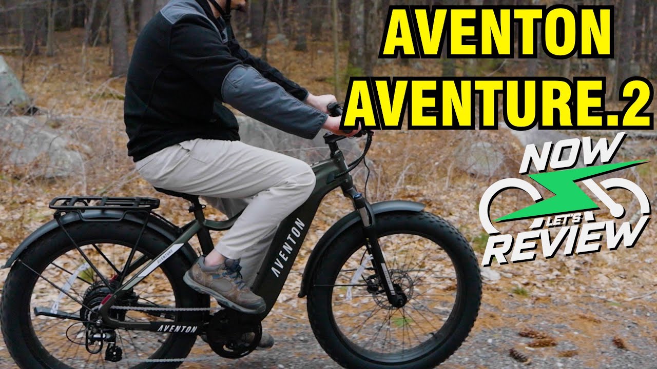 A man is riding an electric bike with the words aventon adventure 2 review while showcasing Ebikes accessories.