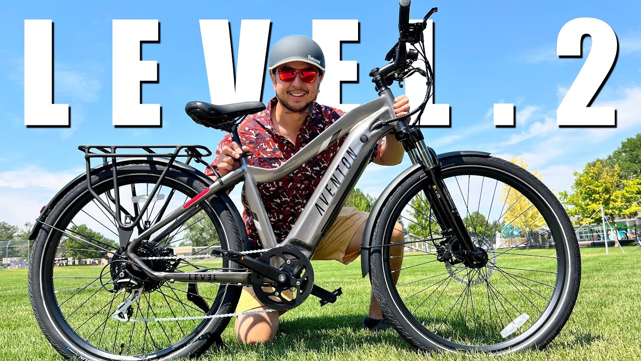 A man is posing next to an electric bike with the words level 2.