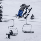 A person doing a jump on a ski lift.