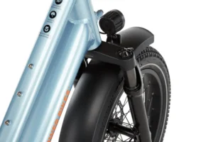 Close-up view of the front wheel and tire of a bicycle with a light blue frame, black fender, and suspension fork.