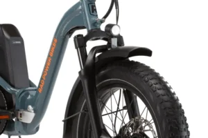 Close-up of the front wheel and fork of a teal Rad Power Bikes electric bicycle, featuring a headlight and thick, knobby tires.