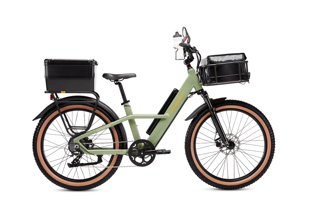 A green electric bicycle with a front basket, rear cargo box, and brown-tinted tires. The bike has a step-through frame and a pedal assist system.