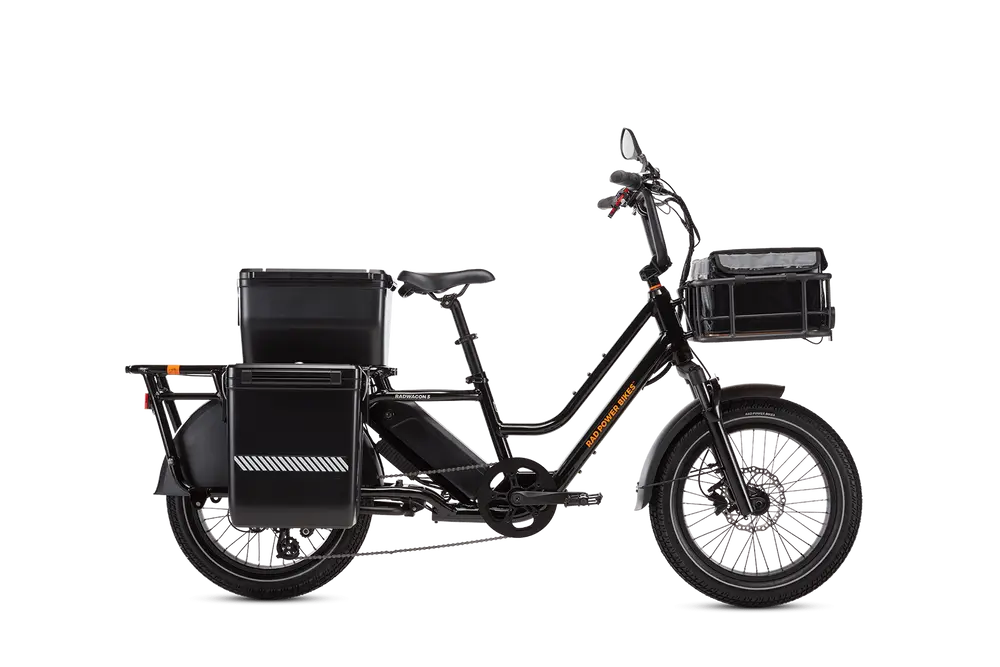 A black cargo electric bike with a sturdy frame, fitted with a large battery, rear storage boxes, and a front rack.