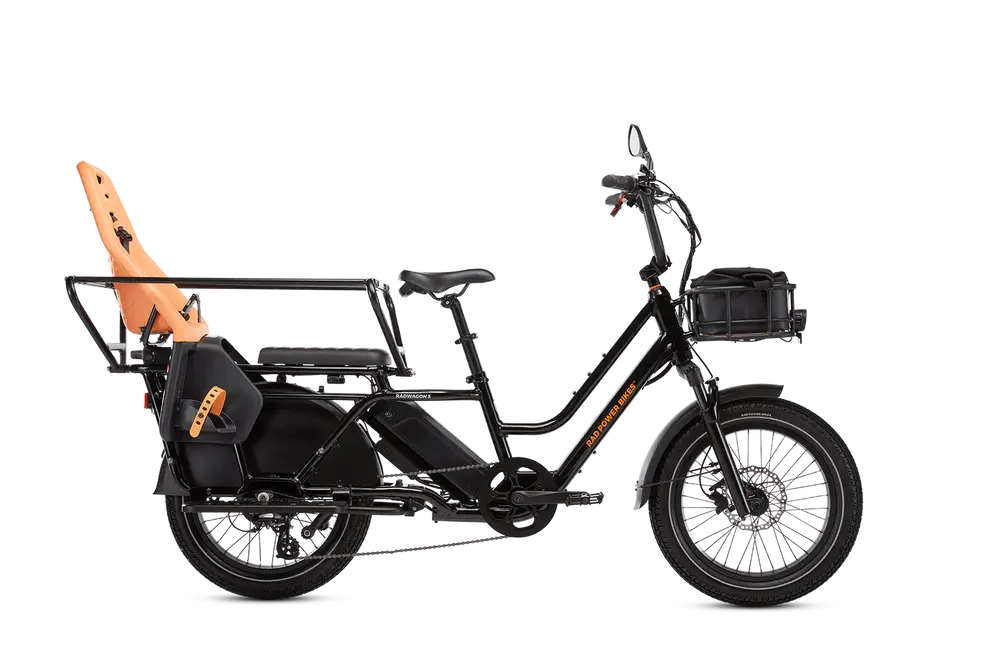 A black cargo e-bike with two seats, one with an orange child seat attached at the rear, and a front storage basket.