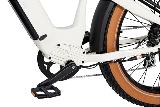 Close-up view of the pedal, chain, and rear wheel of a white bicycle, showcasing the mechanical components and tire.