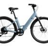 The Carbon 1 Step-Thru is a matte grey electric bicycle featuring a low-step frame, black handlebars, black wheels, a rear fender, and visible chain gear.