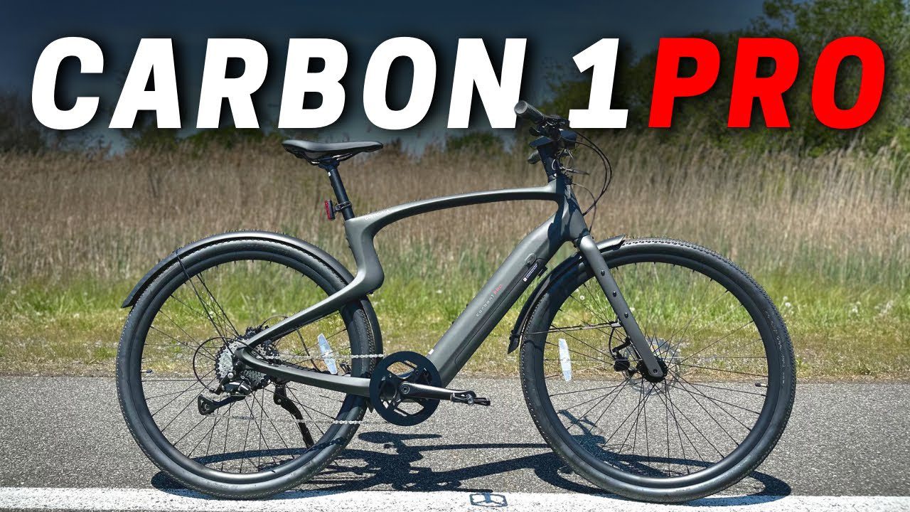 Carbon 1 Pro bicycle on a road, showcasing its design with a dark frame and wheels against a grassy background.