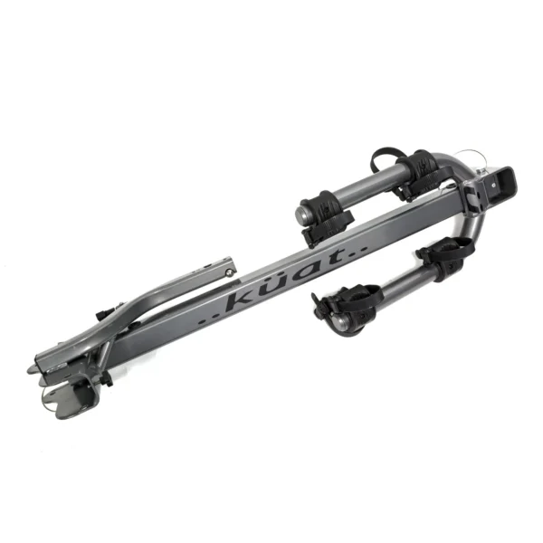 A gray Beta™ bike rack is shown folded, featuring padded arms and adjustable straps for securing a bicycle.