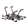 The NV™ 2.0 Add-On is a four-bike hitch-mounted rack featuring black and orange adjustable arms, wheel trays, and securing straps for transporting bikes by vehicle.