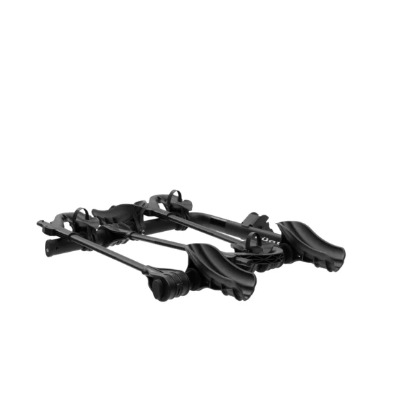 The Transfer™ v2, a black dual-arm car roof bike rack, is shown lying flat on a white background and is designed to securely hold bicycles during transport.