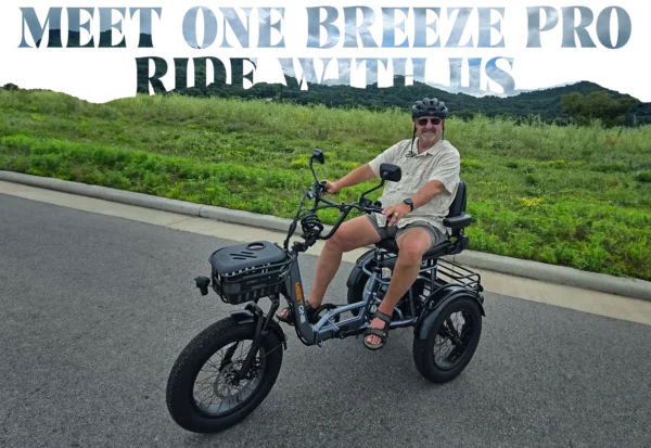 A man in sandals and sunglasses sits on a Meet One Breeze Pro Fat Tire Electric Trike on a paved road, surrounded by greenery and hills. Text above reads “MEET ONE BREEZI PRO - RIDE WITH US.”.