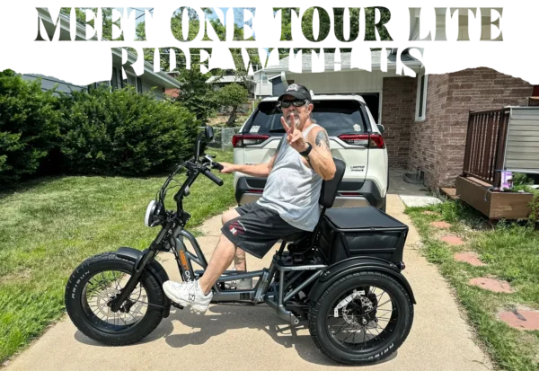 A man in sunglasses and a gray tank top sits on the Meet One Tour Lite Full Suspension Electric Trike in a driveway, flashing a peace sign. A white SUV and greenery are visible in the background.