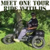 A man wearing a helmet sits on a Meet One Tour Dual Motor Dual Battery Electric Trike under a tree in a grassy park.