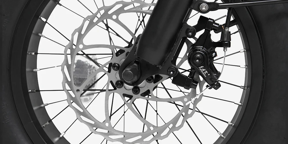 Close-up view of a bicycle wheel featuring a disc brake system with a rotor, caliper, and spokes against a white background.