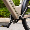 Close-up of the Asphalt Ebike’s pedal and chain area labeled "Torque+Cadence Sensor," with parts of the frame and rear wheel visible.
