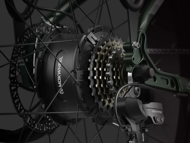 Close-up view of a Mokwheel electric bicycle rear wheel showing the hub motor, gear cassette, and Shimano Tourney derailleur.