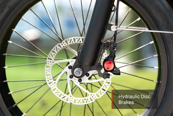 Close-up of the Granite E-Trike's wheel featuring a hydraulic disc brake system, with emphasis on the rotor and caliper. A label reads "Hydraulic Disc Brakes.