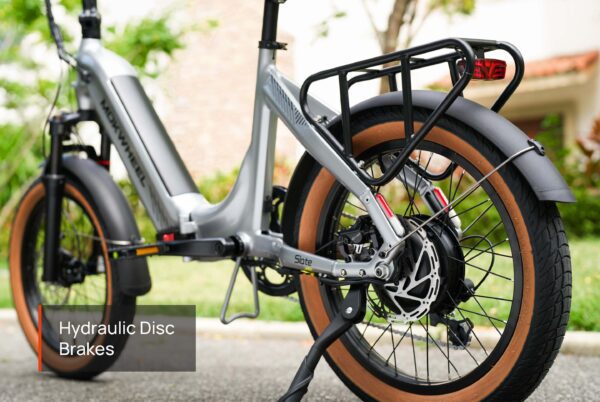 Close-up of the Slate Ebike's rear wheel and frame, showcasing its silver finish, hydraulic disc brakes, and rear cargo rack.