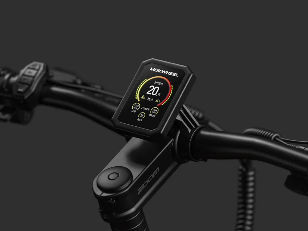 Close-up of an electric bike handlebar with a digital display showing speed, battery level, power, and PAS settings against a plain dark background.