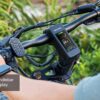 Close-up of a person’s hands on the Onyx Ebike handlebar, featuring a digital display that shows speed and power details.