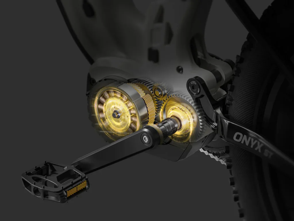 Close-up of a bike’s pedal and crank system, revealing the internal gear mechanism with highlighted golden gears, labeled ONYX GT.