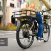 Person riding an Asphalt Ebike with a large front basket filled with groceries; text overlay reads “350 lbs Payload.”.