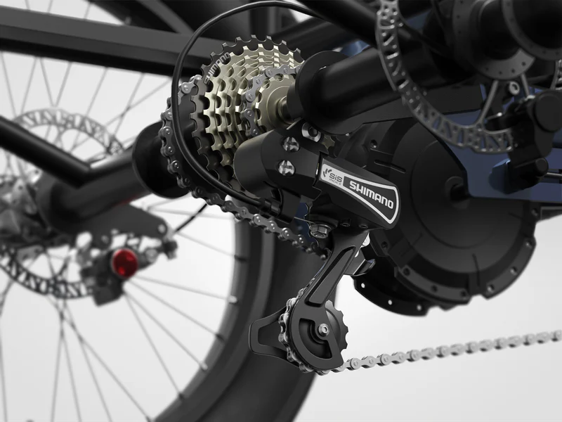 Close-up of a bicycle's Shimano gear derailleur, chain, cassette, and disc brake system. The components are clean and clearly visible.