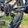 Close-up of the Onyx Ebike's rear wheel featuring a Shimano 10-speed derailleur, cassette, chain, and part of the frame on a grassy surface.