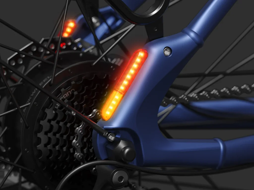 Close-up of a blue bicycle frame showing illuminated orange rear indicator lights and gear mechanism.