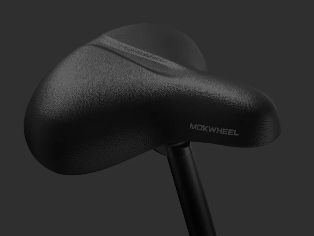 Close-up view of a black bicycle seat with the brand name "MOKWHEEL" on the side, attached to a seat post against a dark background.