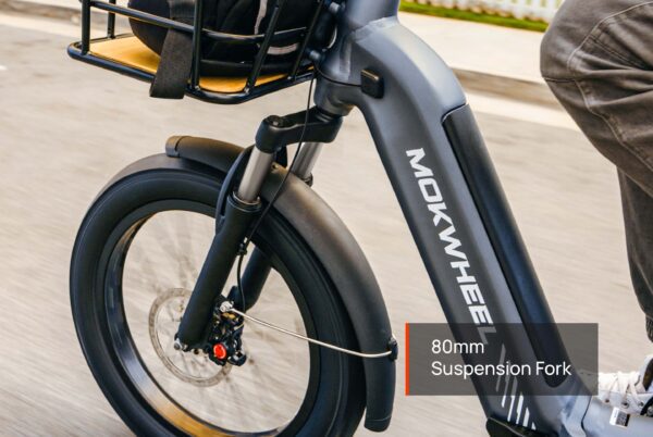 Close-up of the Granite E-Trike’s front wheel and suspension fork, showing the "80mm Suspension Fork" label as the trike is ridden on a paved surface.