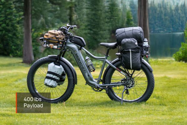 Tor Plus Ebike loaded with camping gear and bags, parked on grass by a lake and forest. Text overlay: "400 lbs Payload".