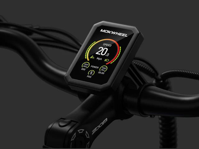 A close-up of a Mokwheel e-bike display showing speed, power, and PAS level on the handlebars against a dark background.