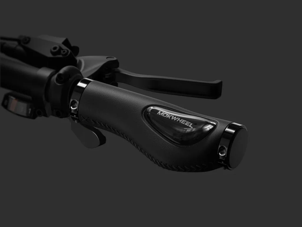 Close-up of a black handlebar grip labeled "MORWHEEL" with a brake lever attached, set against a dark background.